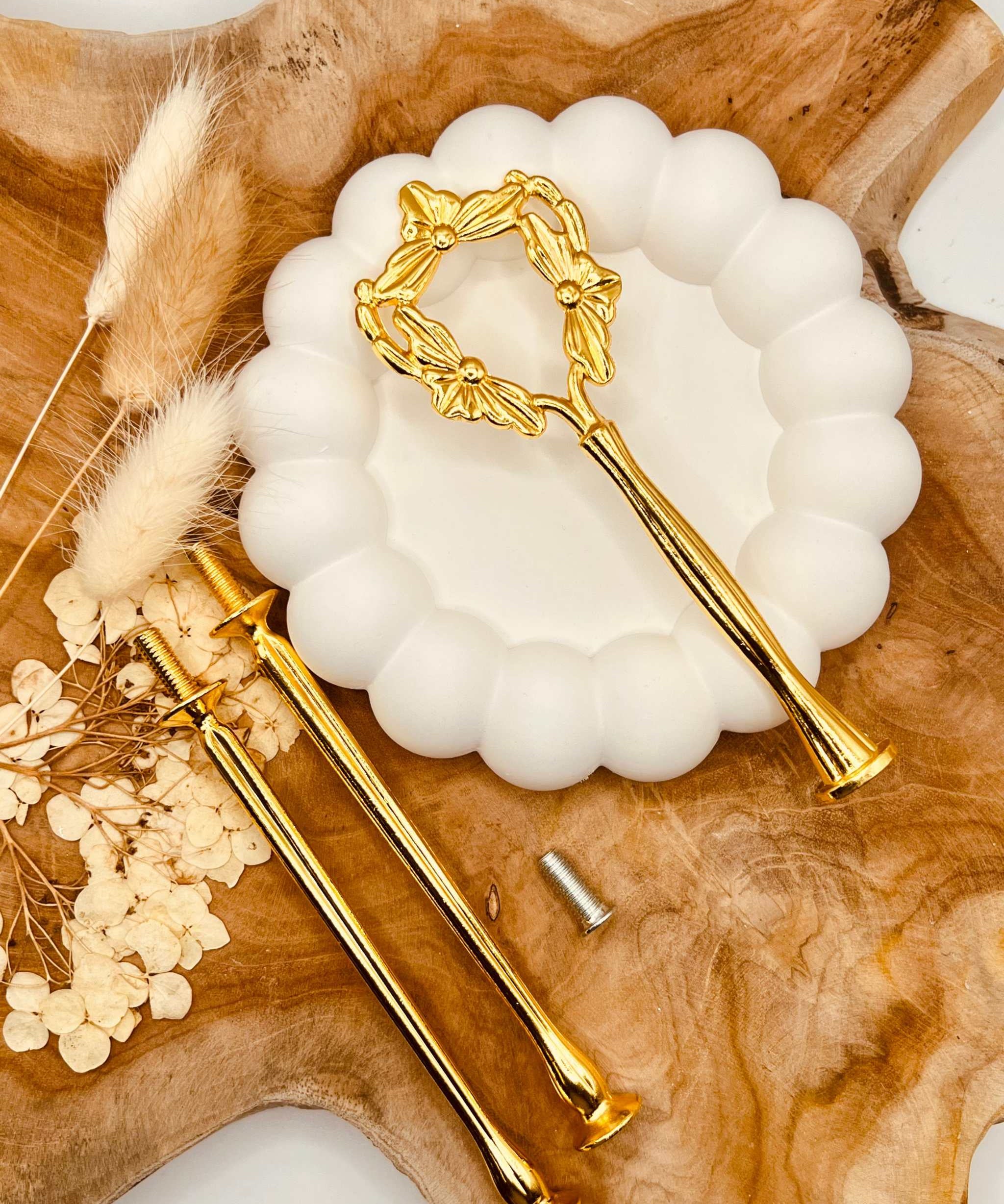 Detailansicht der goldfarbenen Etagerenstange mit Blumenband-Motiv