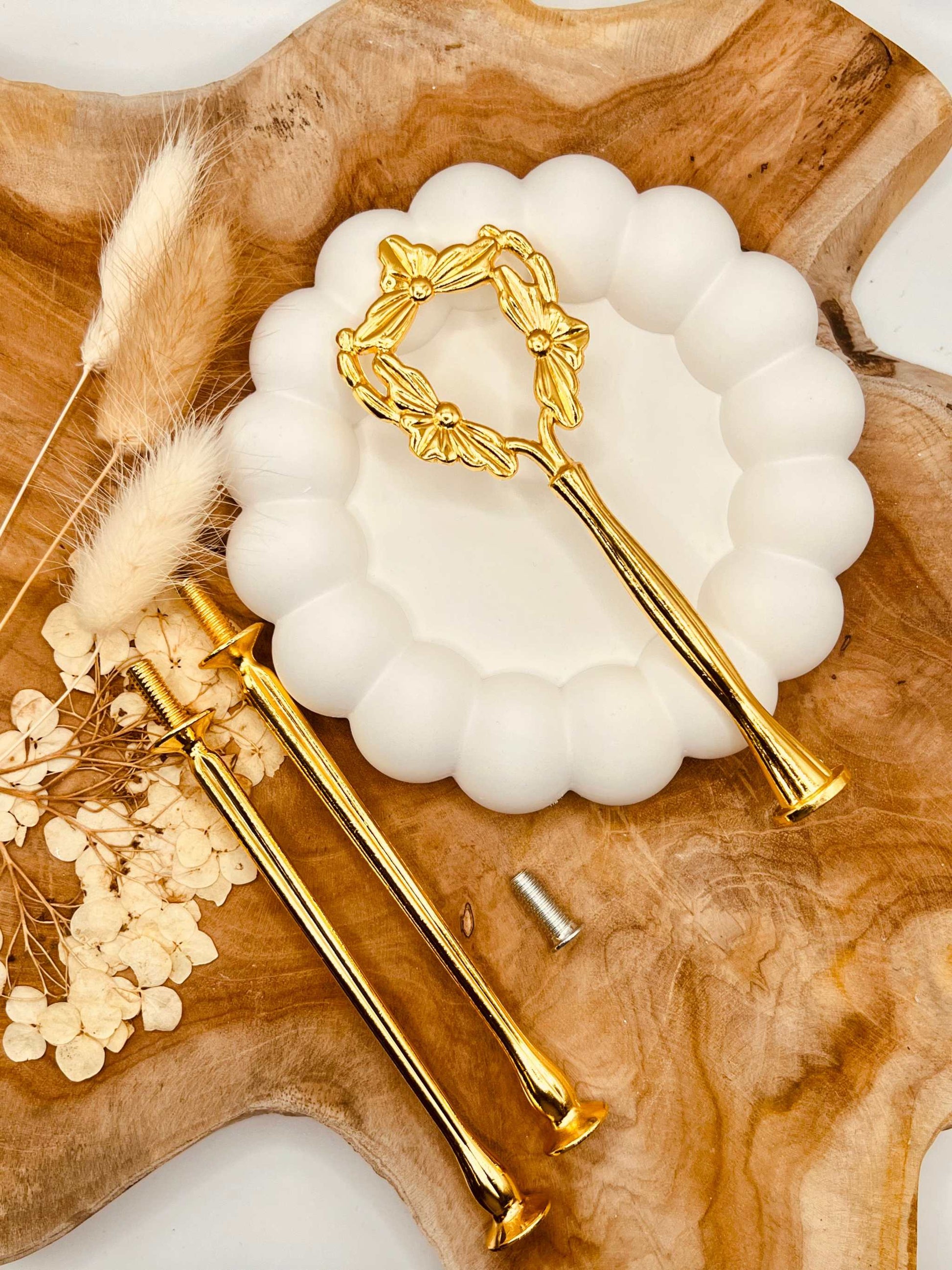Detailansicht der goldfarbenen Etagerenstange mit Blumenband-Motiv