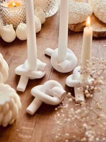 Modern candle holder made of cast ceramic in knot design 