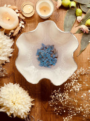 handgemachte weiße Schale aus Resin mit silbernen Details und getrockneten blauen Hortensien auf Holztisch dekoriert