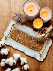 Tablett aus Resin mit goldenen Griffen, dekoriert mit Kerzen und Schmuck auf Holztisch