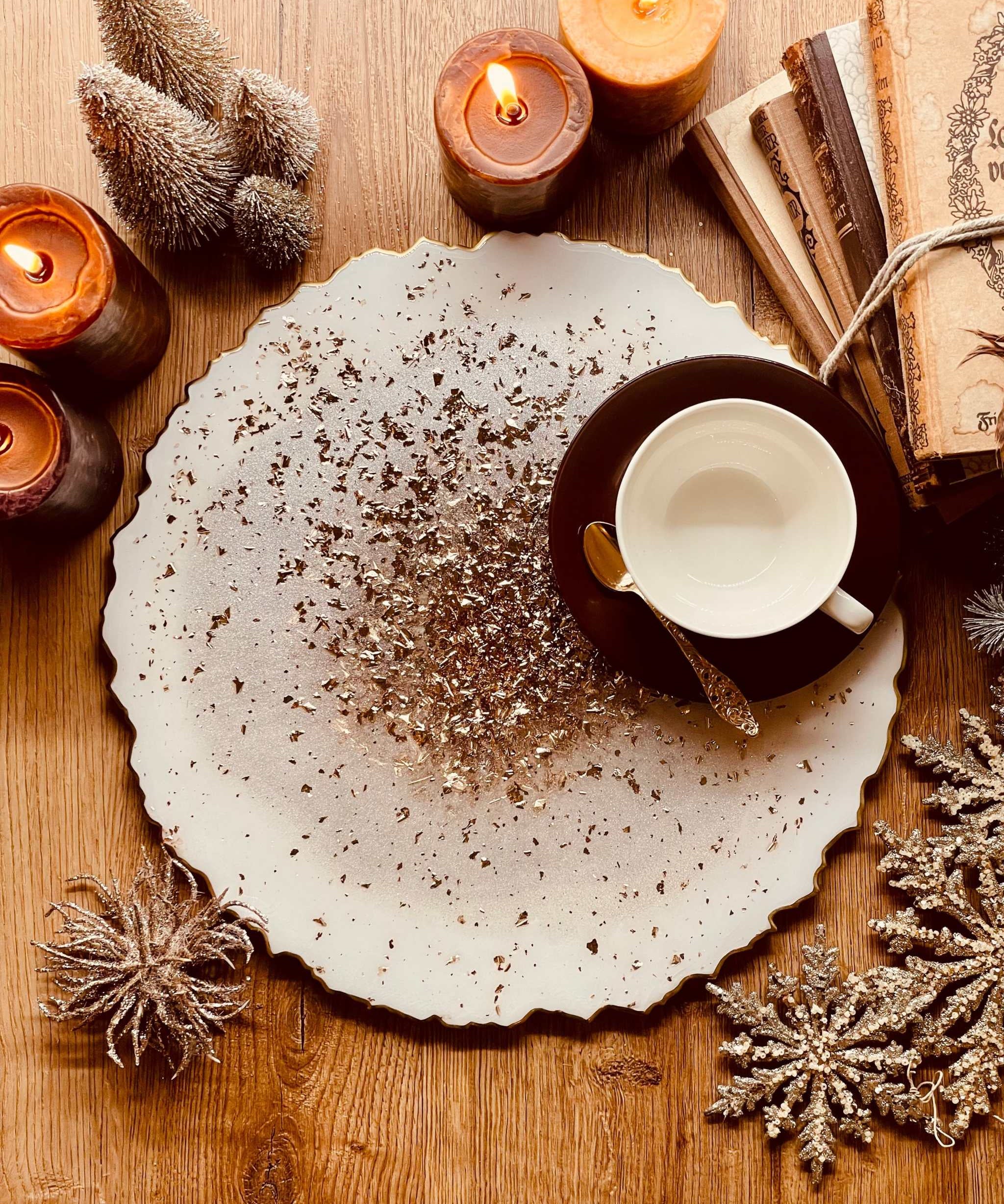 Handgemachtes weißes Tablett aus Resin mit goldenen Details und unregelmäßigem Rand, dekoriert mit Kerzen und einem Kaffeetasse auf Holztisch