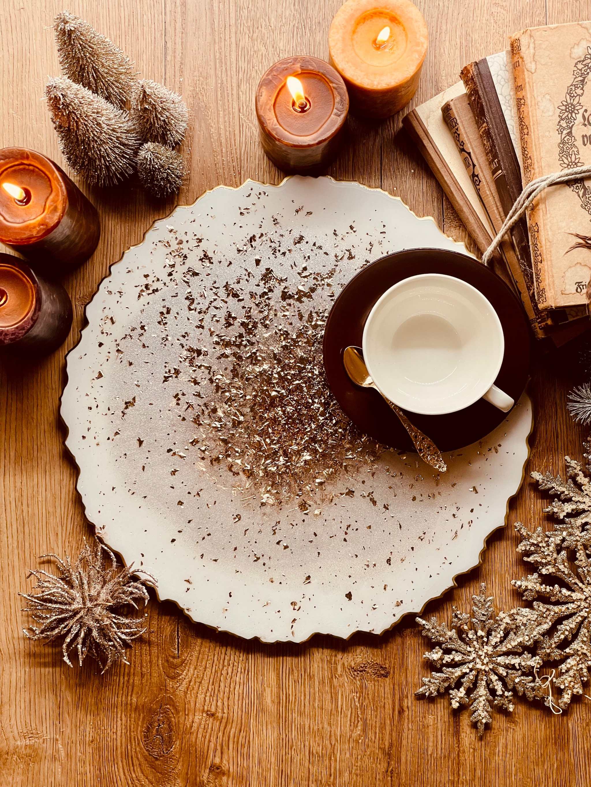 Handgemachtes weißes Tablett aus Resin mit goldenen Details und unregelmäßigem Rand, dekoriert mit Kerzen und einem Kaffeetasse auf Holztisch