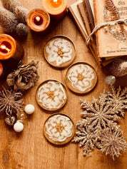 4 exklusive Untersetzer aus weißem Resin mit goldenen Details auf Holzoberfläche neben Kerzen und Weihnachtsdekoration