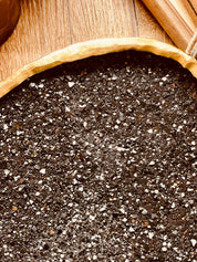 Handgemachte schwarze Schale aus Resin mit goldenen Diamantdetails auf Holztisch