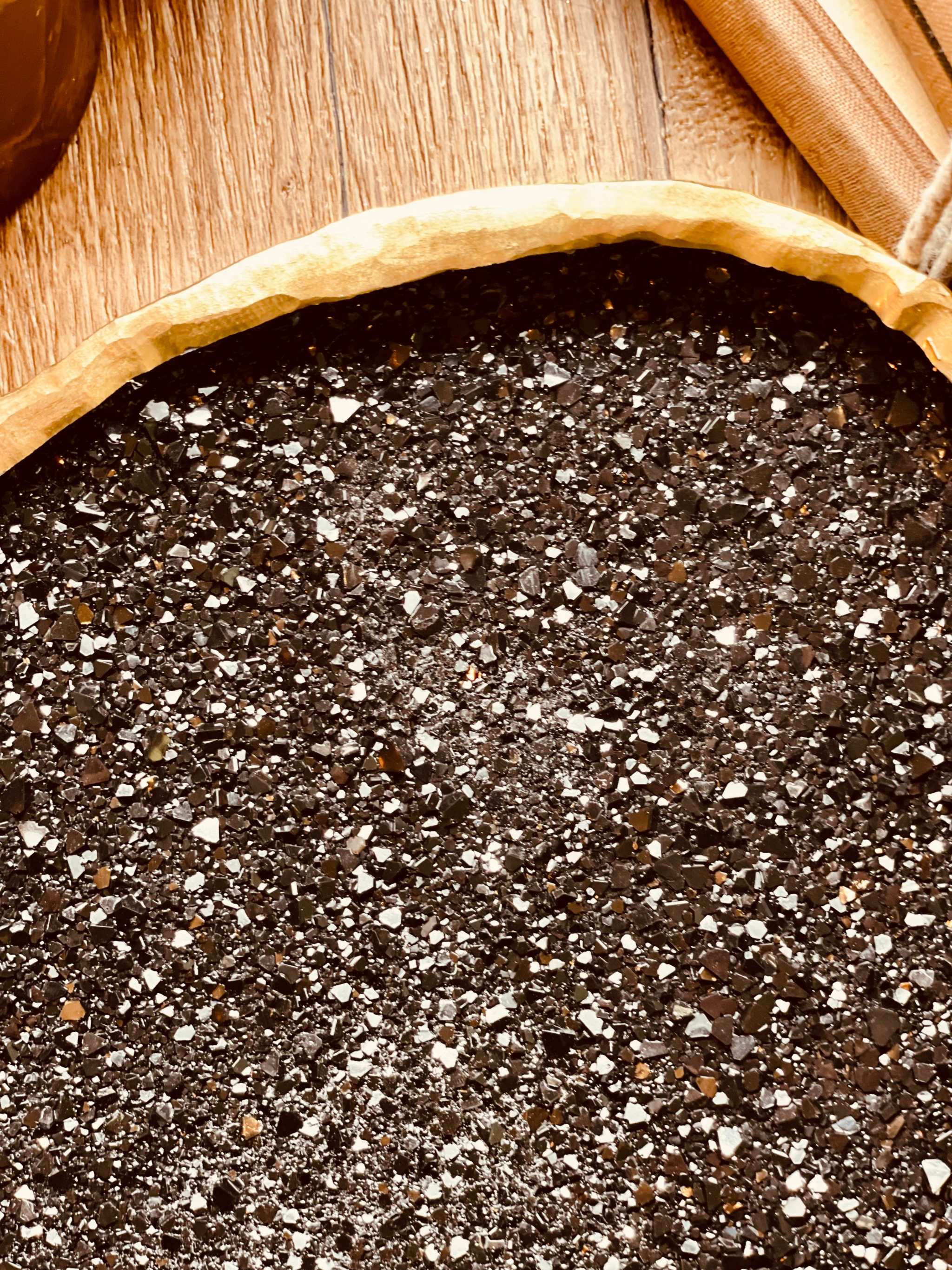 Handgemachte schwarze Schale aus Resin mit goldenen Diamantdetails auf Holztisch