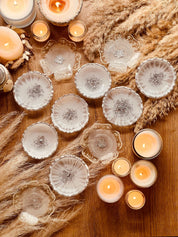 Handgemachte weiße Schmuckschalen aus Resin mit silbernen Details und Kerzen dekorativ auf Holztisch