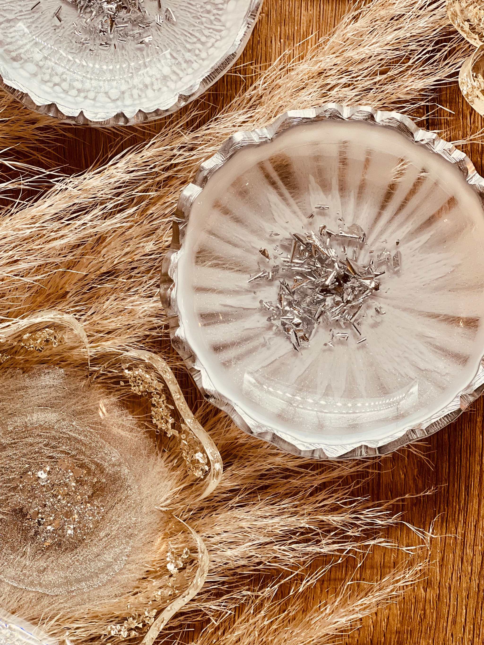 handgemachte weiße Schmuckschalen aus Resin mit silbernen Details auf natürlichem Hintergrund