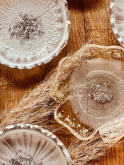 handgemachte weiße schalen aus resin mit silbernen details als schmuckschalen auf holzoberfläche