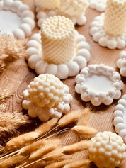 Handgegossene Kerze aus Rapswachs in kreativer Form – ein umweltfreundliches, veganes Geschenk für jede Gelegenheit. Die Kerzen werden mit handgemachten, weissen Tabletts aus Giesskeramik zum Blickfang.