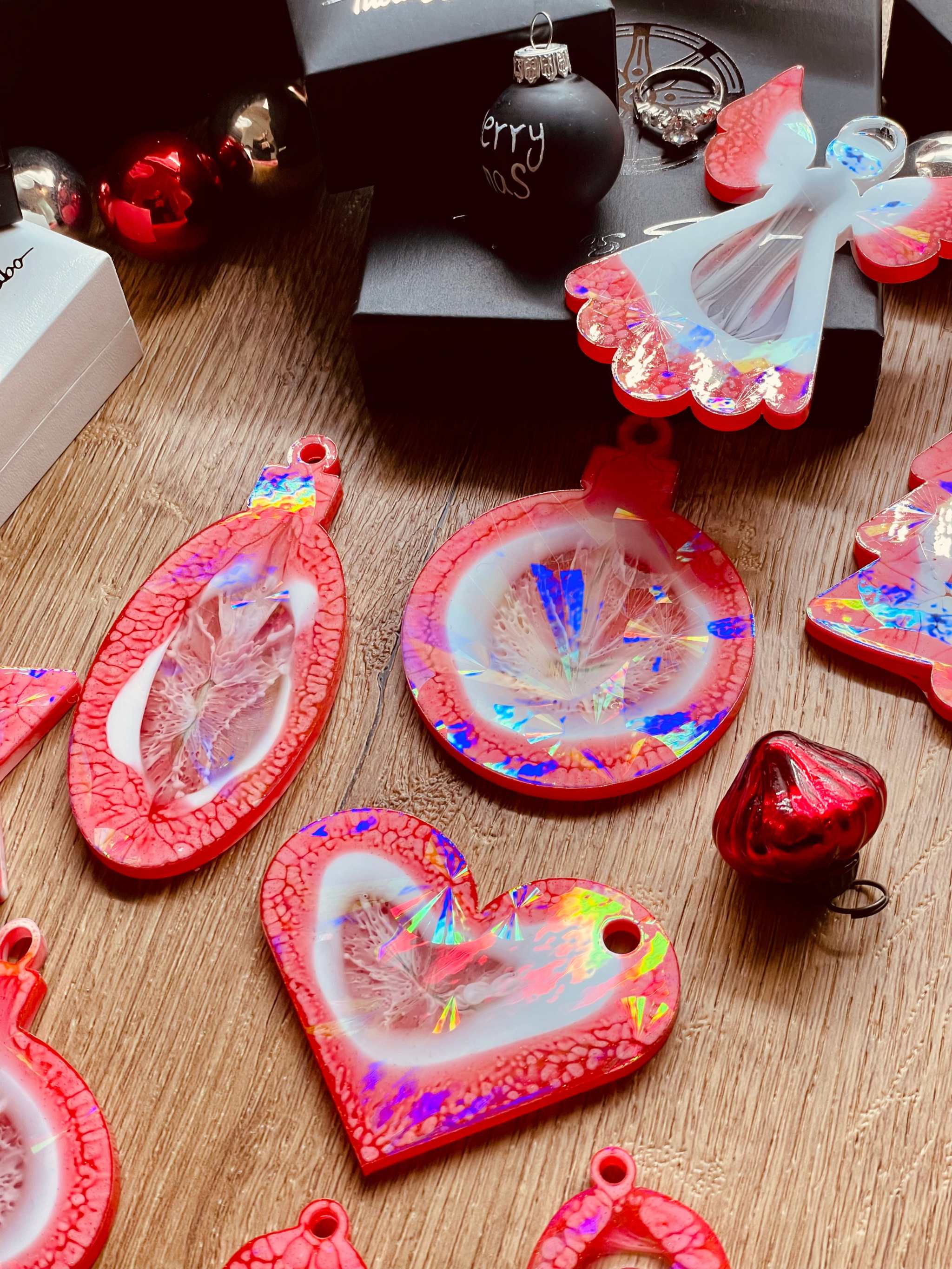 Red and white resin Christmas tree ornaments with holographic surface.