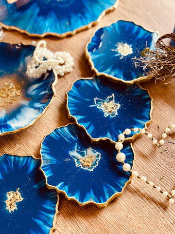 4 resin coasters in blue with gold