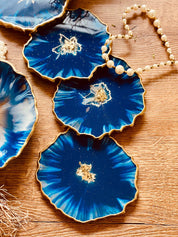 4 Untersetzer aus Resin in Blau mit goldenen Details auf Holztisch handgemacht einzigartig
