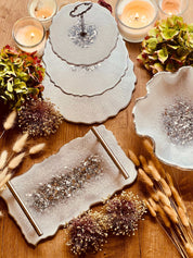 Handgemachte individuelle Deko Sets aus Resin mit unregelmäßigen, geschwungenen Formen auf Holztisch mit Kerzen und Trockenblumenarrangements