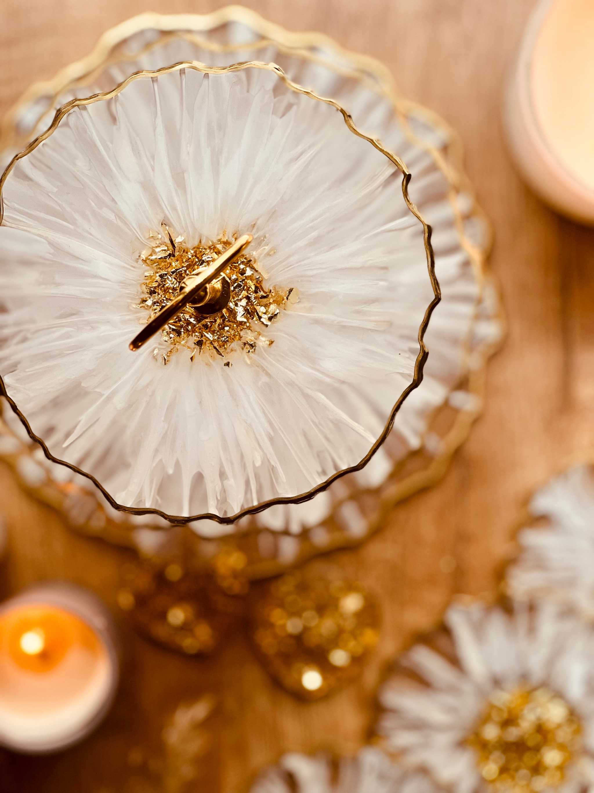 Deko Set aus handgefertigtem Epoxidharz mit 3D Weiß-Gold Muster und glänzenden goldenen Akzenten, edle Etagere auf Holztisch mit Kerzenlicht