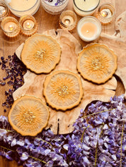 Handgemachte individuelle Untersetzer aus Resin mit goldenen Details, dekorativ auf Holzplatte mit Kerzen und lila Blumen