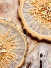 4 Untersetzer aus Resin in beige mit goldenen Details handgemacht auf Holzoberfläche