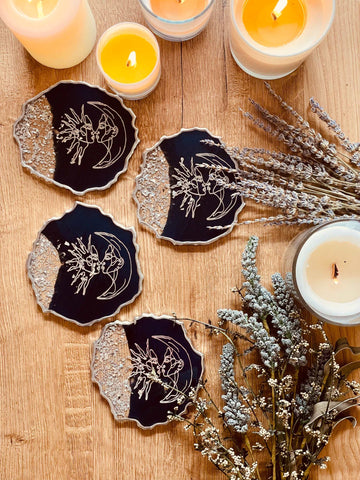 4 resin coasters in dark blue with silver and line art
