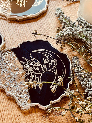 4 resin coasters in dark blue with silver and line art