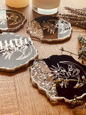 4 handgemachte Untersetzer aus Resin in dunkelblau mit silberner LineArt und unregelmäßigen Rändern, 12cm Durchmesser, dekorativ auf Holztisch