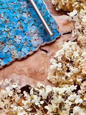 Handgemachtes Tablett aus Resin mit blauen Hortensien und silbernen Details auf Holzuntergrund