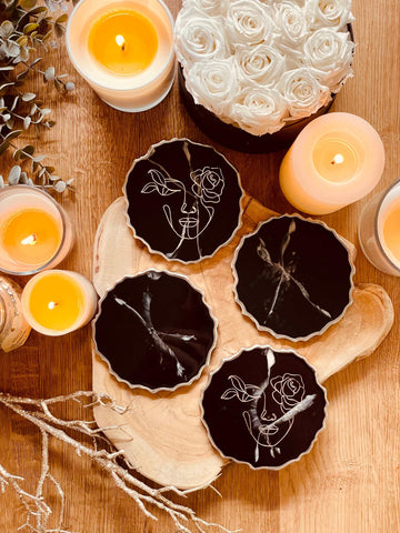 4 resin coasters in black with silver and line art