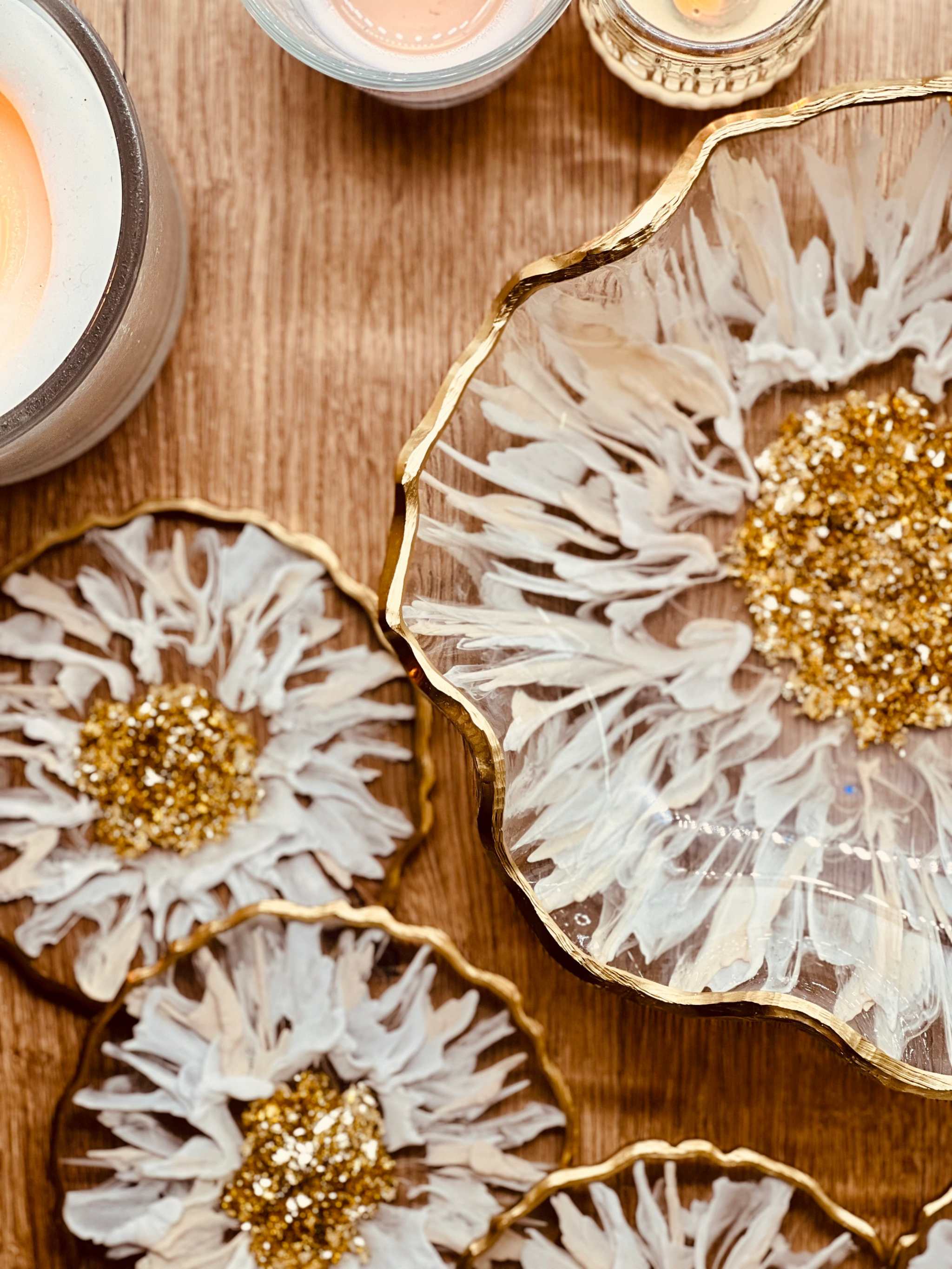 Weiß-goldenes handgefertigtes Deko Set aus Epoxidharz mit 3D-Streifenmuster, bestehend aus Schalen und Untersetzern mit goldenen Akzenten auf Holztisch