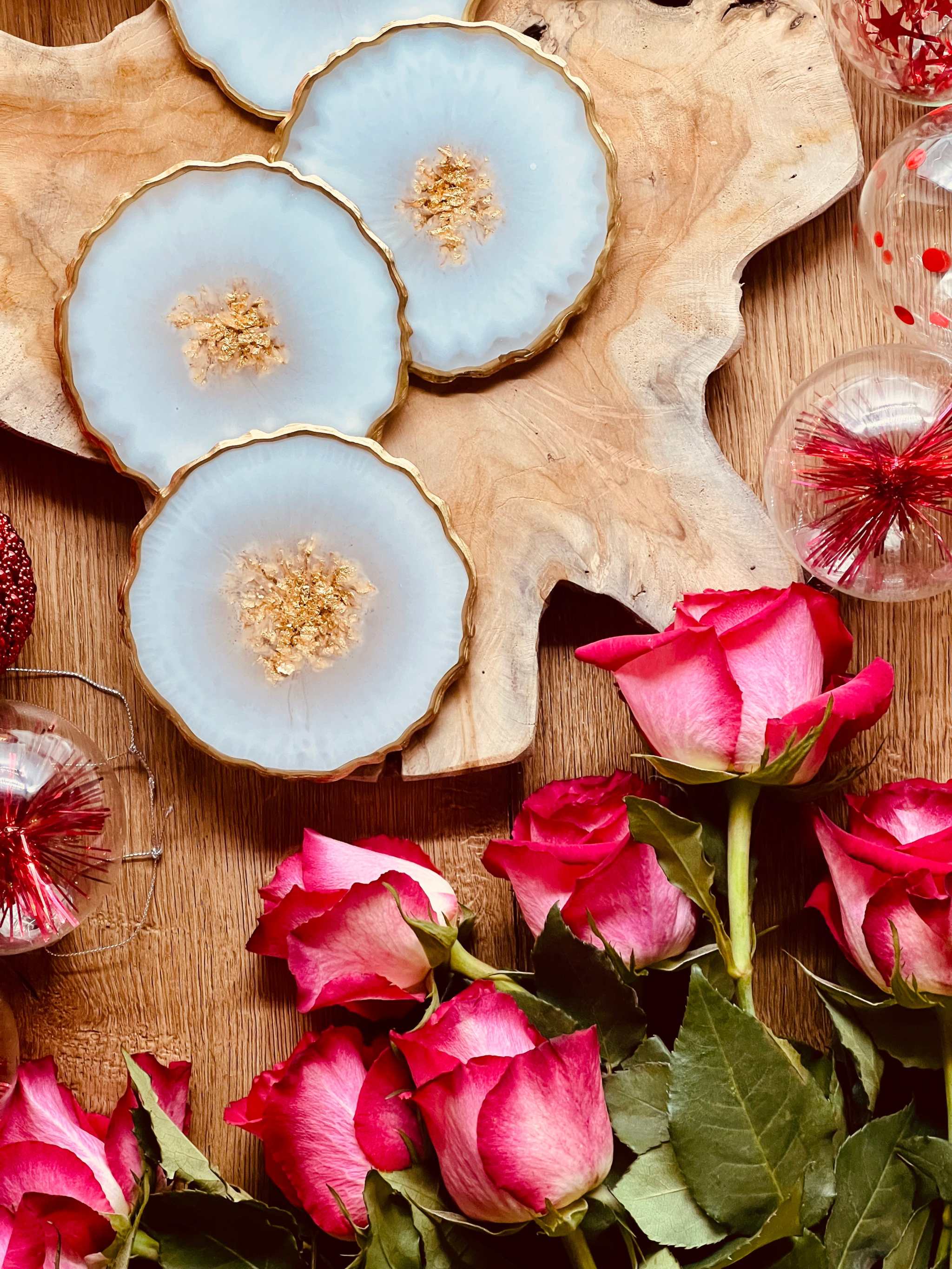 Set aus 5 handgemachten Untersetzern aus weißem Resin mit goldenen Details auf Holzplatte, dekoriert mit rosa Rosen und Weihnachtskugeln