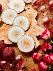 Fünf handgemachte weiße Untersetzer aus Resin mit goldenen Details auf Holzplatte als Dekoration und Geschenkidee