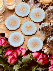 6 Untersetzer aus weißem Resin mit goldenen Details im 6er Set auf Holztisch mit Dekoration