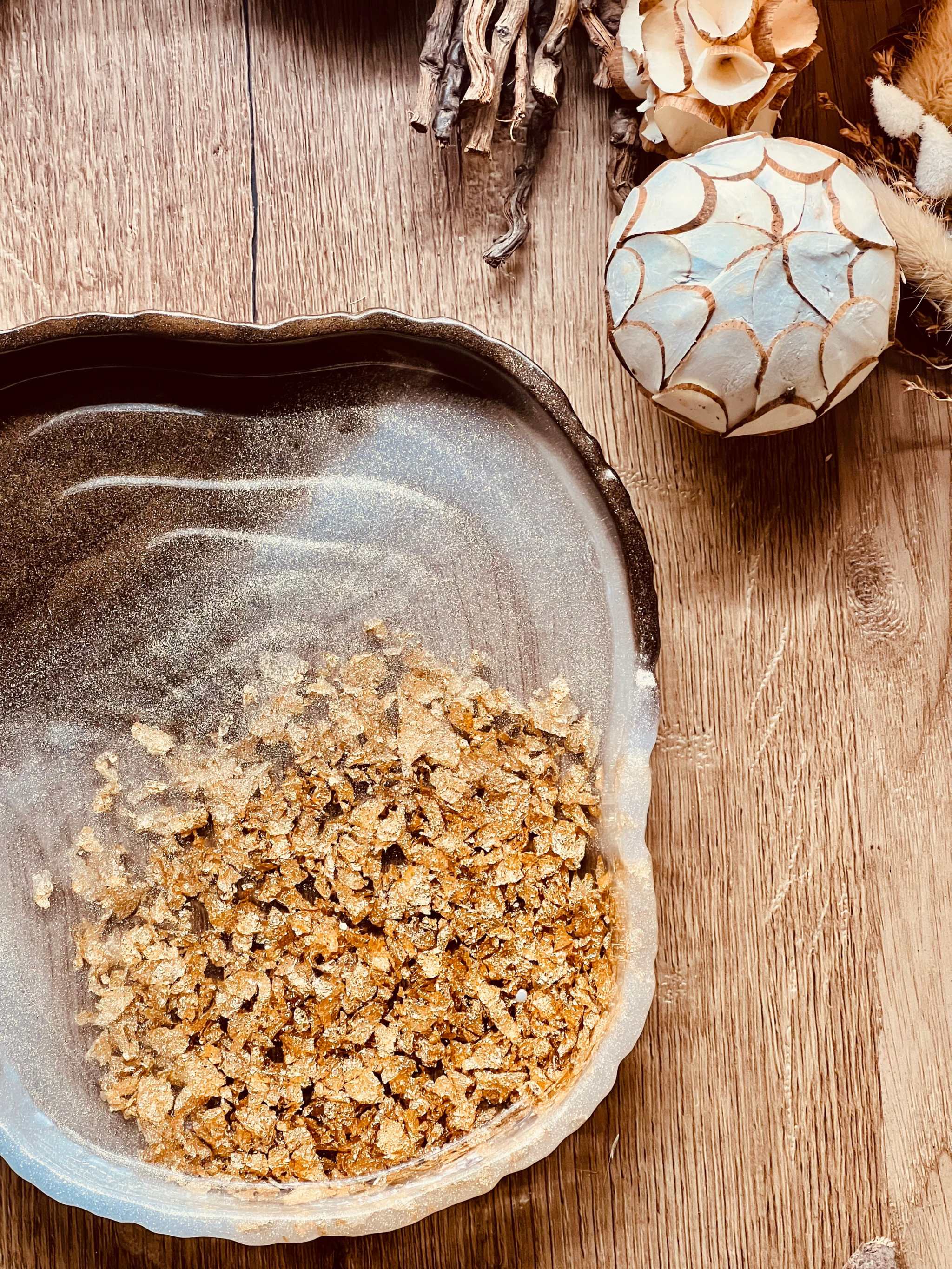 Handgemachte braune Schale aus Resin mit goldenen Details auf Holztisch