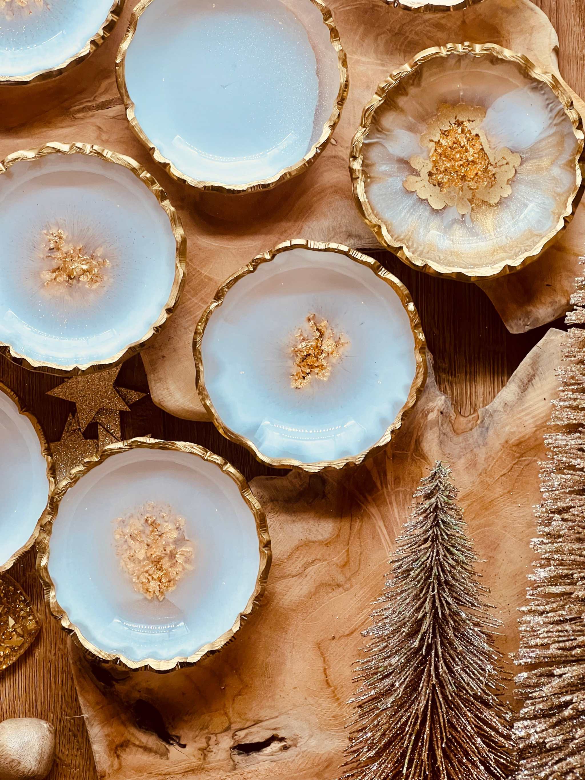Weisse handgemachte Schmuckschalen aus Resin mit goldenen Details auf Holztisch als Dekoration