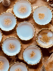 Handgemachte weiße Schmuckschalen aus Resin mit goldenen Details und ca. 10cm Durchmesser, ideal als Dekoration oder Geschenk.