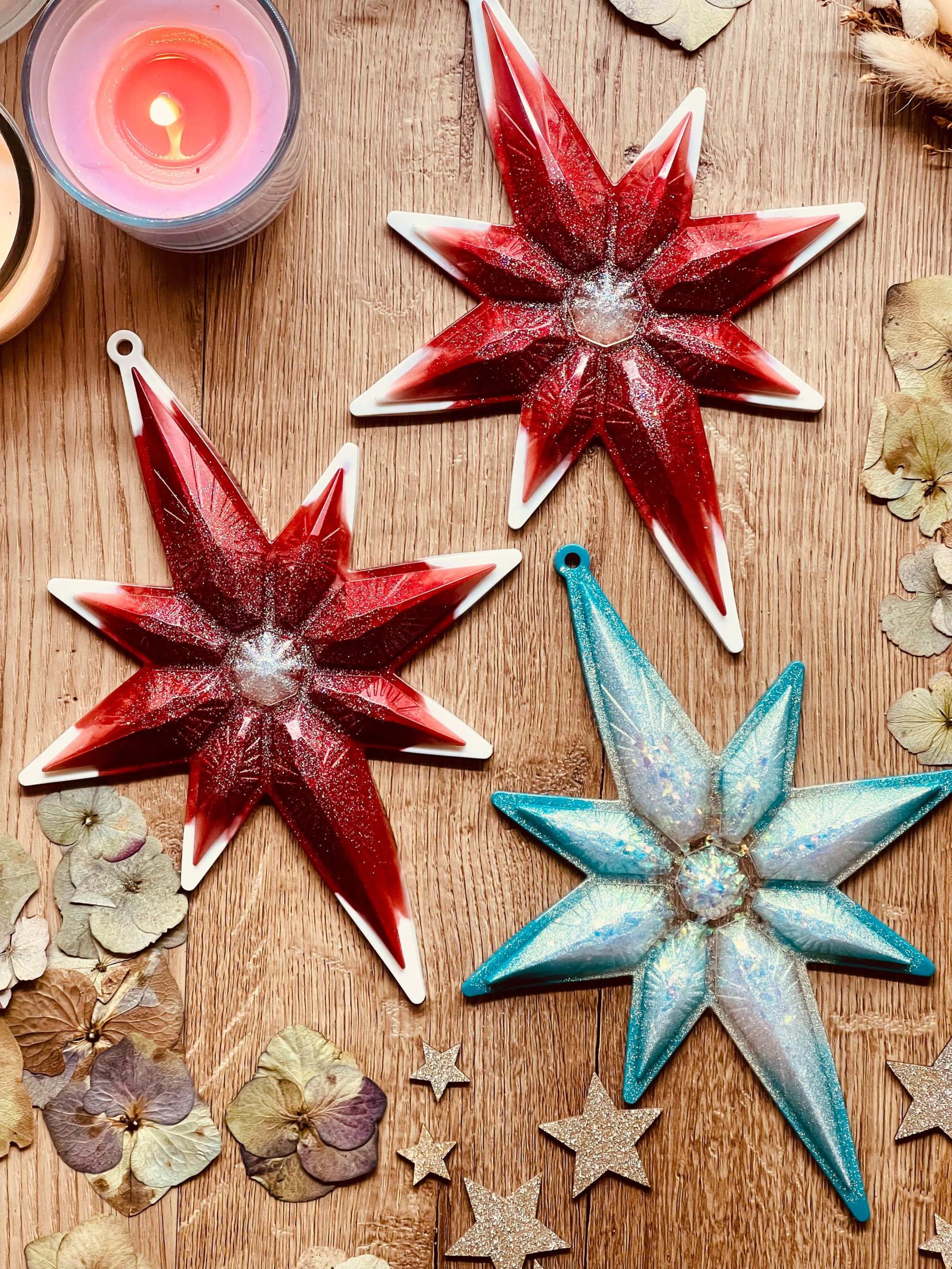 Handmade resin Christmas tree ornaments in red or turquoise with white and silver accents.