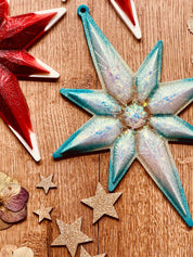Handmade resin Christmas tree ornaments in red or turquoise with white and silver accents, unique and eye-catching decorations.