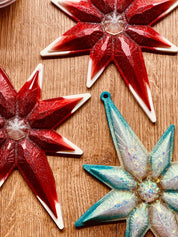 Handmade resin Christmas ornaments in red or turquoise with white and silver accents, measuring approximately 23x18cm.