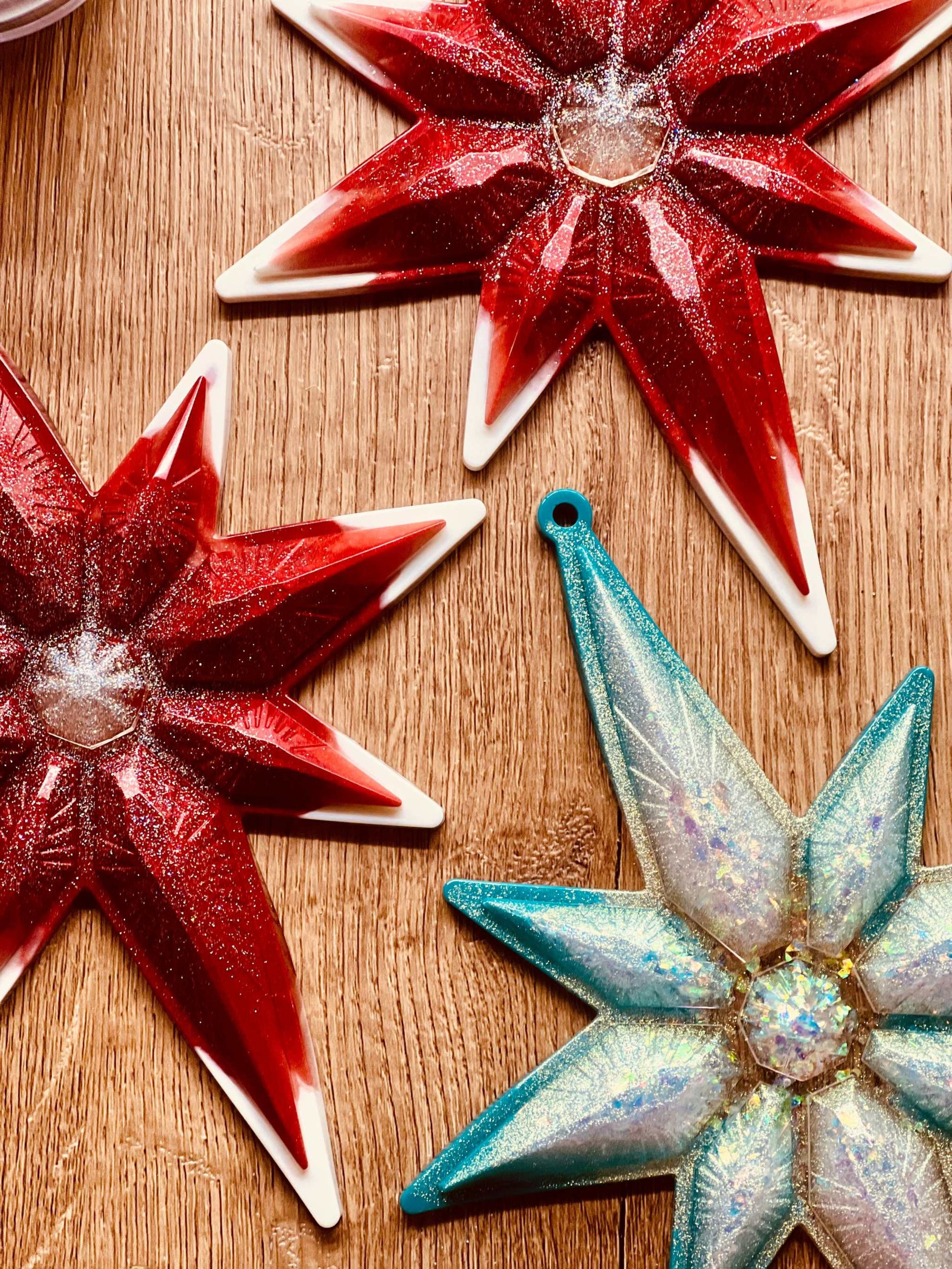 Handmade resin Christmas ornaments in red or turquoise with white and silver accents, measuring approximately 23x18cm.