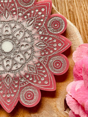 Handgemachter pinker Mandala Untersetzer aus Resin mit silbernen Details auf Holzunterlage, 12 cm Durchmesser