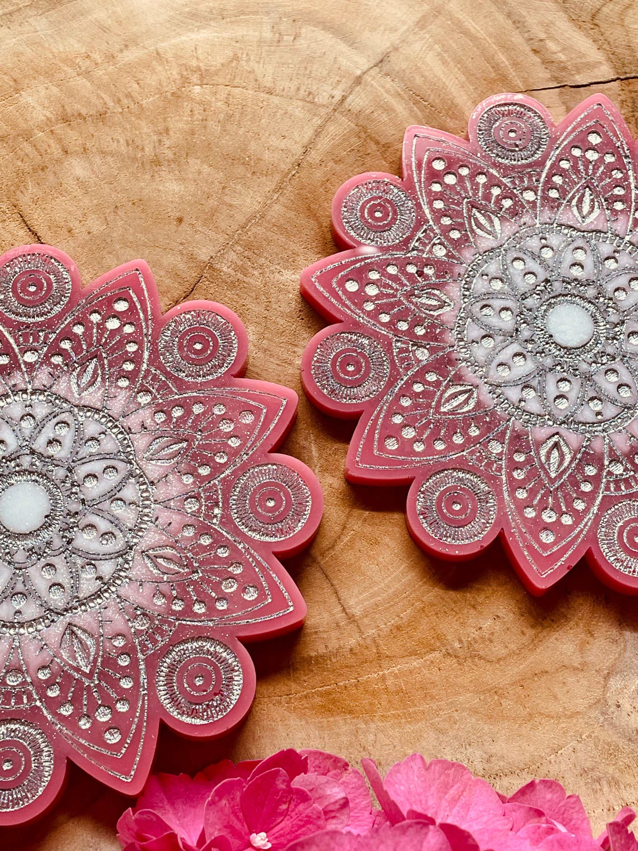 2 handgemachte Mandala Untersetzer aus Resin in Pink mit silbernen Details auf Holzfläche