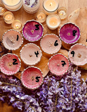 Handgemachte Schmuckschalen aus Resin in verschiedenen Pinktönen mit silbernen Rändern, dekorativ arrangiert mit Kerzen und Blumen