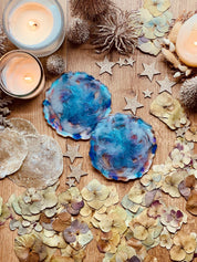 2 Untersetzer aus handgemachtem blauem Resin auf Holztisch mit Kerzen und Dekoration