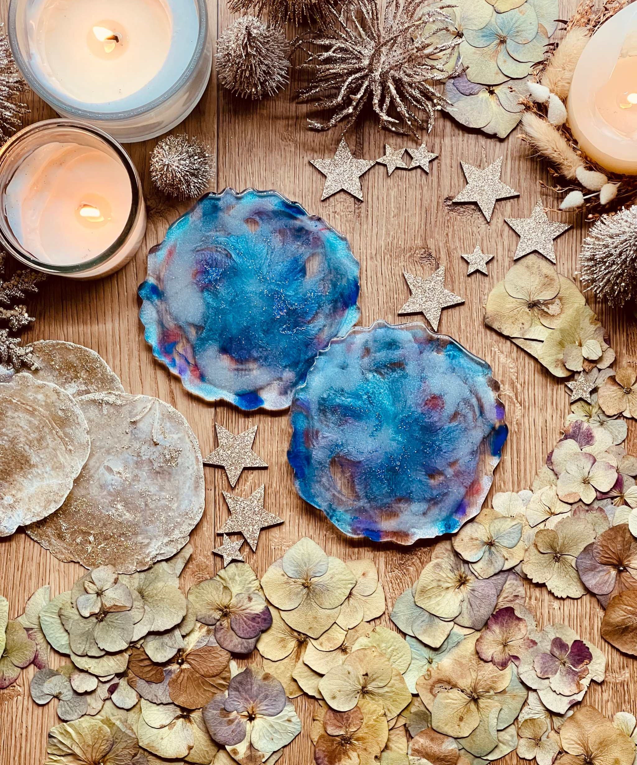 2 Untersetzer aus handgemachtem blauem Resin auf Holztisch mit Kerzen und Dekoration