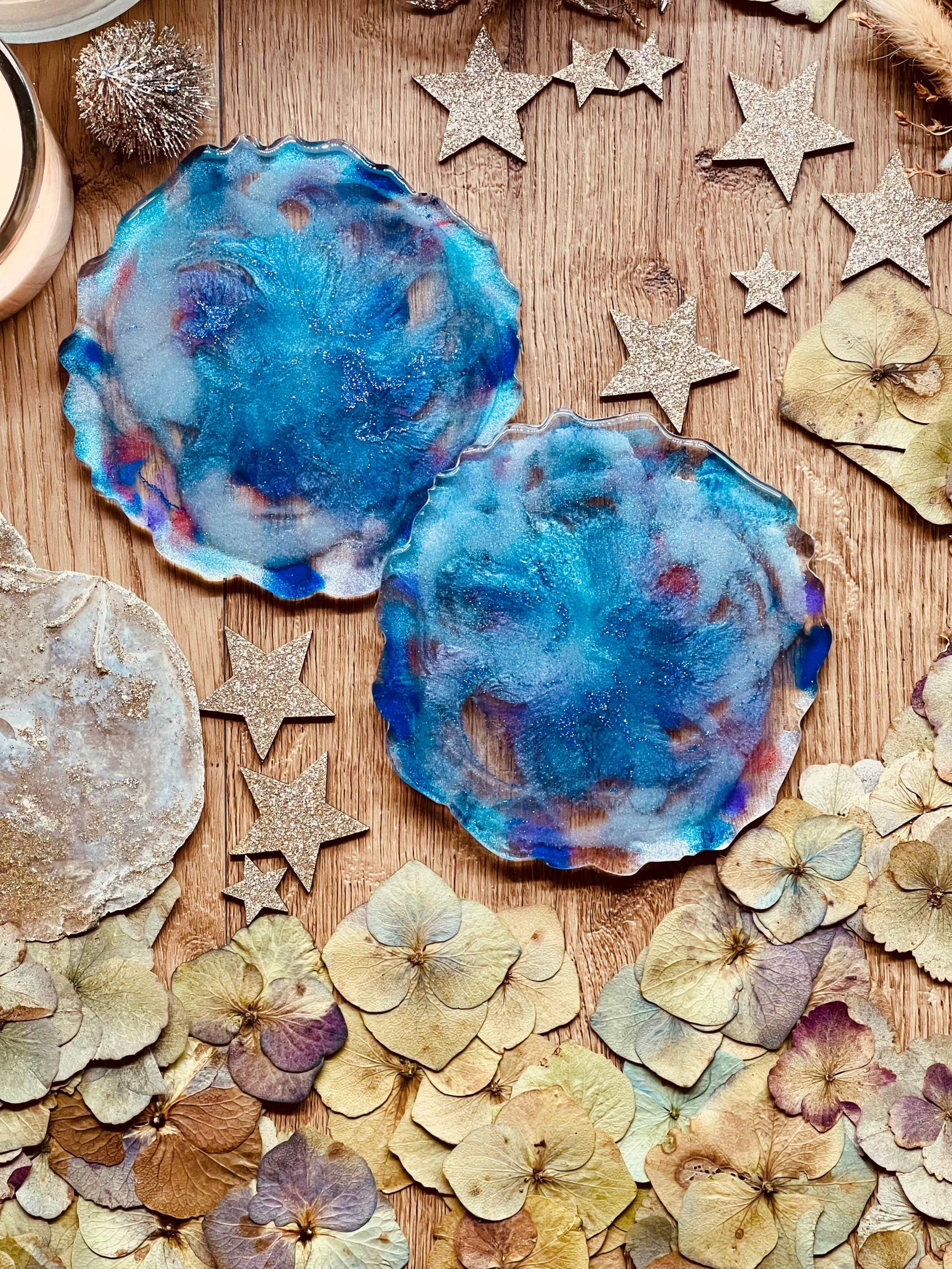 2 Untersetzer aus handgemachtem blauem Resin mit einem Durchmesser von ca. 12 cm auf dekorativem Holztisch