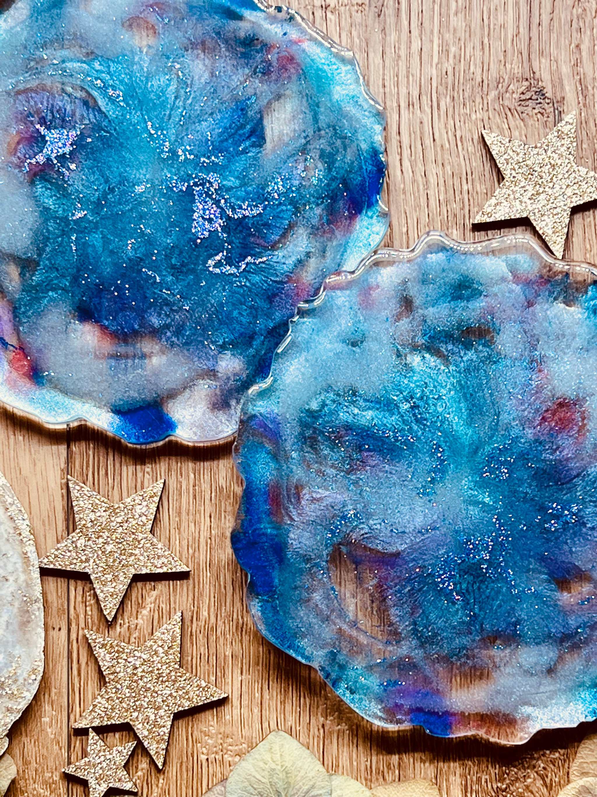 2 handgemachte Untersetzer aus Resin in Blautönen als einzigartiges 2-teiliges Set auf Holztisch
