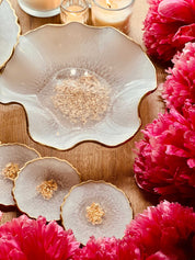 handgemachte Deko Sets aus Resin mit goldenen Akzenten und unregelmäßigen Formen umgeben von pinken Blumen