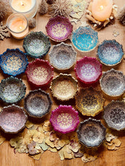 bunte handgemachte Mandala Schmuckschalen aus Resin auf Holztisch mit Kerzen und Dekoration