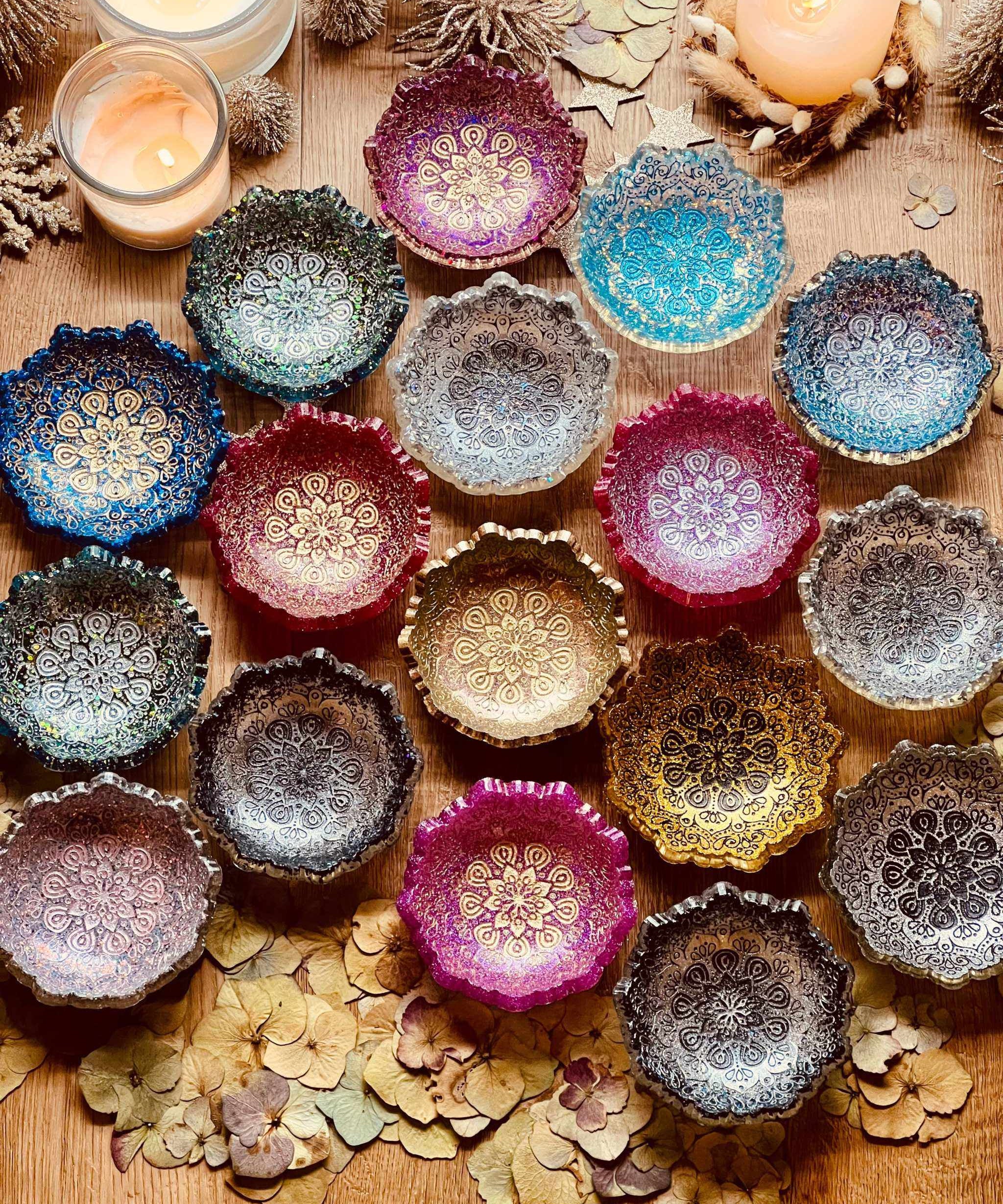 bunte handgemachte Mandala Schmuckschalen aus Resin auf Holztisch mit Kerzen und Dekoration