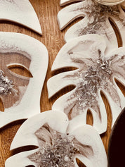 Weißes handgemachtes Resin Tablett und 4 Untersetzer mit silbernen Monstera Details auf Holzuntergrund