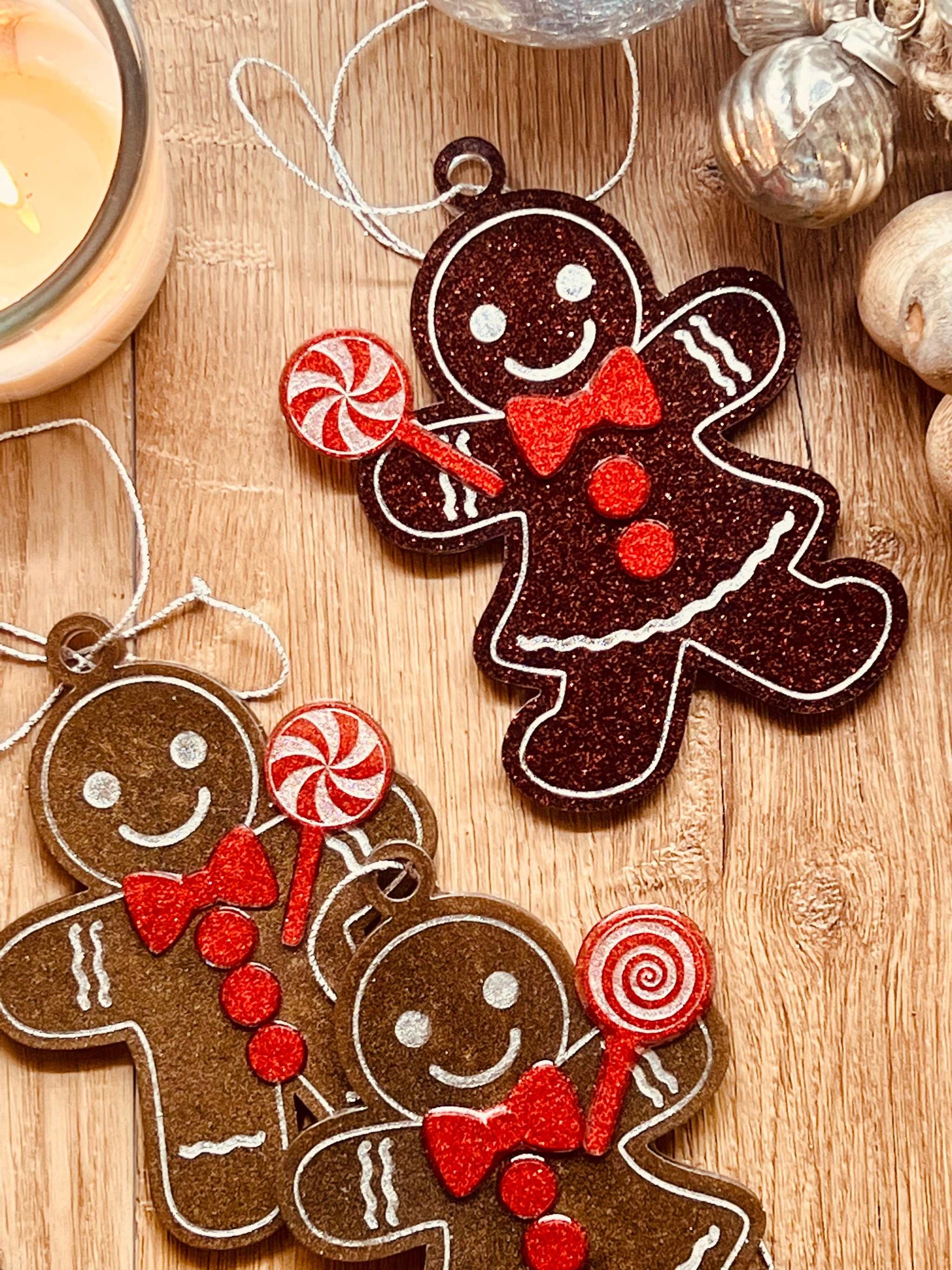 Handmade resin gingerbread men Christmas tree ornaments in brown and red tones.