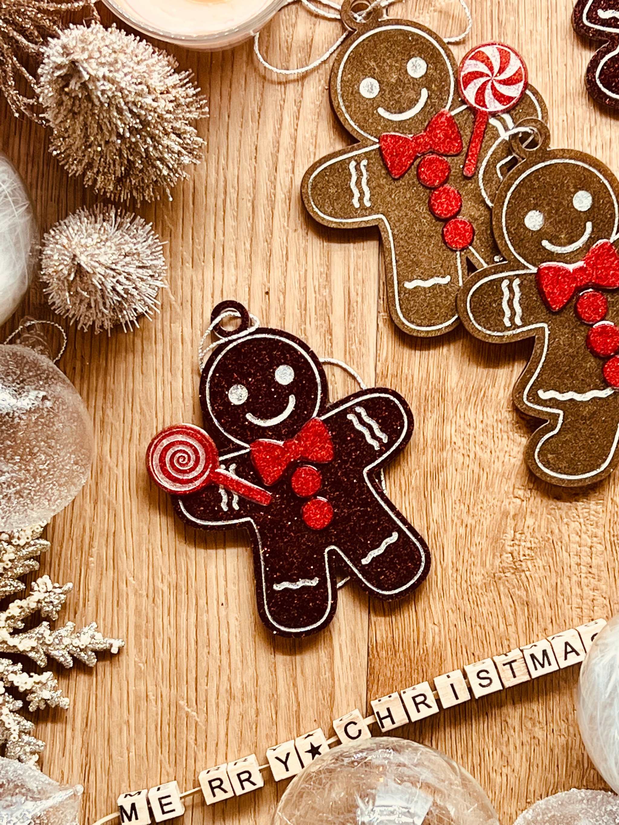 Handmade resin gingerbread man Christmas tree ornaments in brown and red tones.